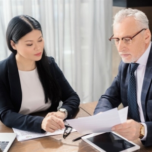 businessman and asian businesswoman talking and lo JFYEGK7