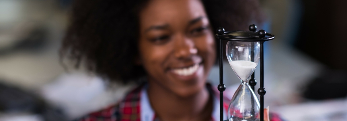 young woman at office looking at sand clock PPH7Z8K 2 1 scaled 1